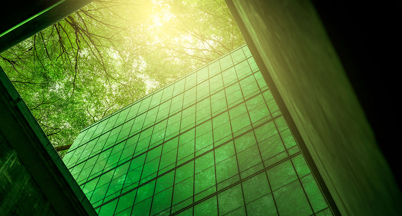 Eco-friendly building in the modern city. Sustainable glass office building with tree for reducing heat and carbon dioxide. Office building with green environment. Corporate building reduce CO2.